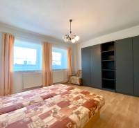 Bedroom with a built-in wardrobe, double bed, and an armchair in a 2-room apartment.