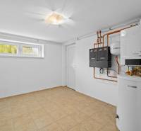 Heating, white walls, and a window with a heat pump on Pluhová Street in a family house.
