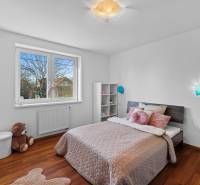 Children's room on Pluhova Street, family house, wooden floor, bed, plush bear.