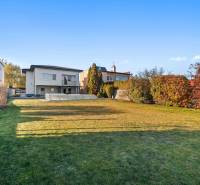 A family house with a swimming pool, a well-maintained lawn on Pluhová Street, surrounded by greenery.