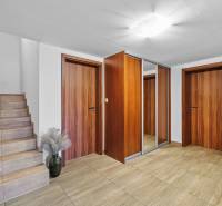 Entrance hall in a family house with wooden doors and a staircase on Pluhová Street.