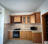 A kitchen in a 5 or more room apartment with wooden cabinets and appliances, tiled floor.
