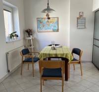 Dining area in a 5 or more room apartment with a table, map, and wooden chairs.