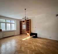 A spacious living room with a wood-patterned floor in a 5 or more room apartment.