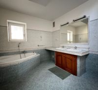 A bathroom in a 5 or more room apartment with a corner bathtub and double sink.