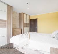 Bright bedroom with a wooden bed and a built-in wardrobe in a 3-room apartment.