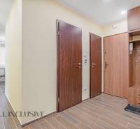 Entrance hallway with wooden doors and flooring in a 3-room apartment.