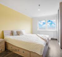 A bright bedroom in a 3-room apartment with wooden furniture and a large window.