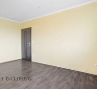 A spacious room with wooden flooring and yellow walls in a 3-room apartment.