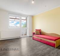 Bright living space in a 3-room apartment with wooden flooring and a sofa.
