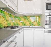 A kitchen in a 3-room apartment with colorful fruit tiles and modern appliance equipment.