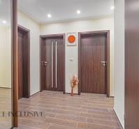 Interior of a 3-room apartment with wooden doors and flooring, subtle wall decoration.