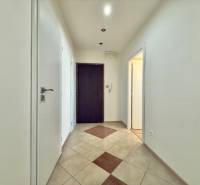 A hallway in a 3-room apartment with light walls and tiled flooring.