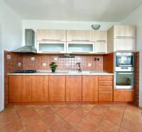 A kitchen in a 3-room apartment with wooden cabinets and ceramic tiles.