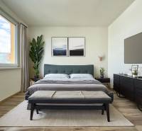 A bright bedroom in a 3-room apartment with a large bed, plants, and minimalist furniture.