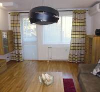 Living room of a 3-room apartment with wooden furniture, a sofa set, and decorative curtains.