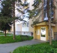 Entrance to the apartment building on Karpatská Street, Prešov, surrounded by trees.