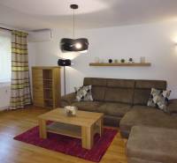 Living room in a 3-room apartment with a sofa, shelf, and floor lamp.