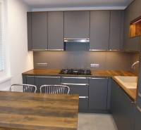 A kitchen with dark cabinets and a wooden countertop in a 3-room apartment.