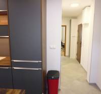 A kitchen unit in a 3-room apartment with black and wooden elements.