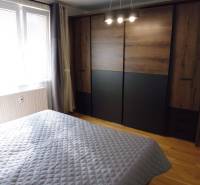 A bedroom with a bed, a window, and a built-in wardrobe in a 3-room apartment.