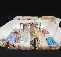 Virtual view of a 2-room apartment with a living room, dining table, and two beds.