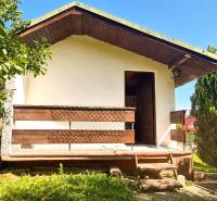 A cottage in Mojš surrounded by greenery, with a terrace and stairs in a natural setting.