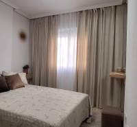 Bedroom in a 3-room apartment with a bed, curtains, and decorative pillows.
