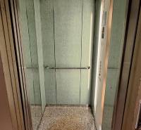 Open elevator with handrails and control panel.