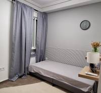 Bedroom in a 3-room apartment with a bed, clock, and nightstand.