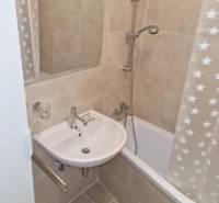 Bathroom with a bathtub, sink, and mirror in a 2-room apartment.