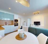 Kitchen and living room in a 3-room apartment, with a dining table and a sofa.