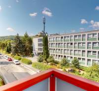 View from the balcony on Študentská Street in Trenčín with surrounding nature and buildings.