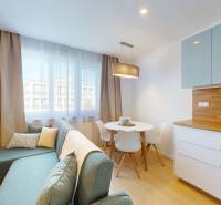 The living room in the 3-room apartment includes a sofa, a round table, and a kitchen.