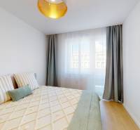 Bedroom in a 3-room apartment with a bed, pillows, and a window with curtains.