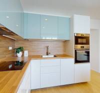 A kitchen in a 3-room apartment with a wooden countertop and built-in appliances.