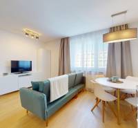 Living room in a 3-room apartment, with a dining table, sofa, and television.