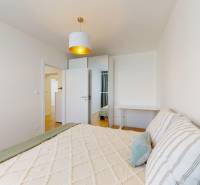 A bedroom with a bed, wardrobe, and lamp in a 3-room apartment.