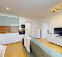 Living room with kitchen in a 3-room apartment, light wood and white furniture.