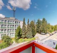 View from a 3-room apartment on Študentská Street in Trenčín, overlooking greenery and a building.