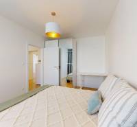 Bright bedroom in a 3-room apartment with a bed and a built-in wardrobe.
