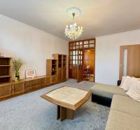 Living room in a 3-room apartment with wooden furniture and a sofa, pleasant atmosphere.
