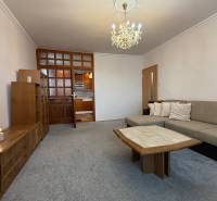 Living room in a 3-room apartment with a sofa, coffee table, and chandelier.