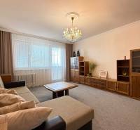 Living room with a sofa, wooden furniture set, and chandelier in a 3-room apartment.