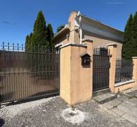 A family house on Sládkovičova Street in Kolárovo with a wrought iron gate and trees along the fence.