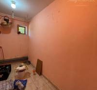 Storage space of a family house with light pink walls and tiled floor.