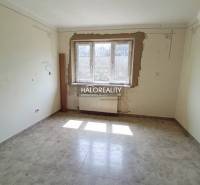 A hallway in a family house with orange walls and checkered tiles.