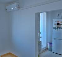A kitchen in a 3-room apartment with air conditioning, a refrigerator, and a microwave.