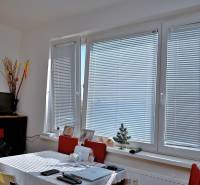 A bright room with large windows and a table in a 3-room apartment.