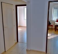 A hallway in a 3-room apartment with a view of the dining room and a room.